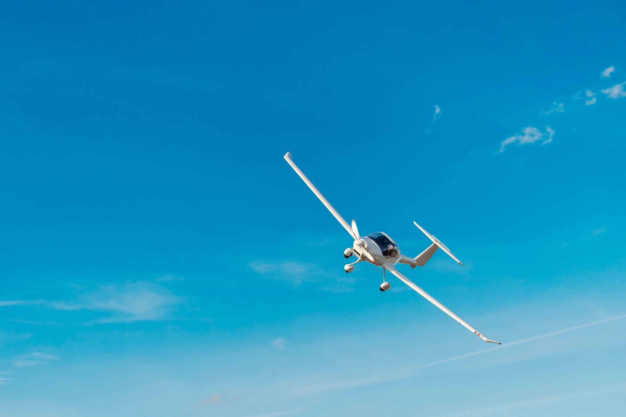 Small propeller airplane flying in clear blue sky
